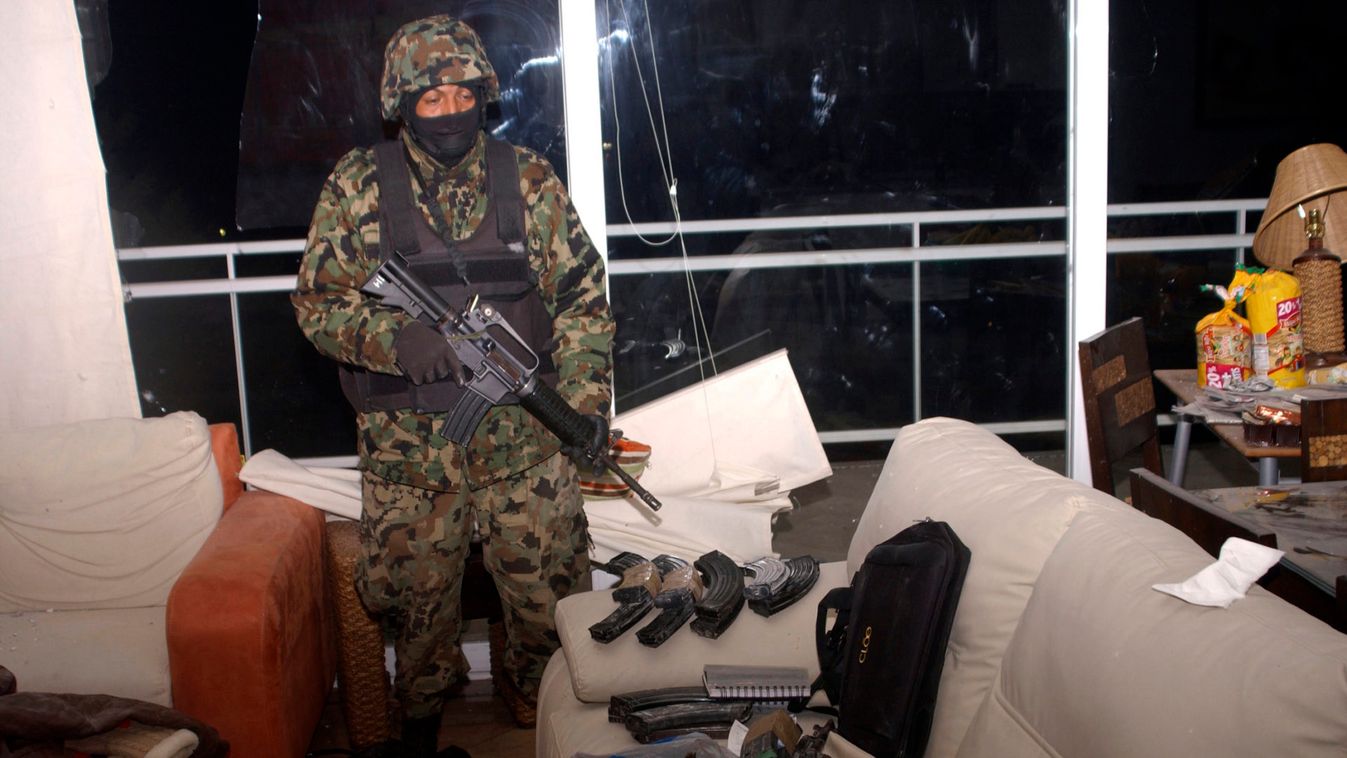 A member of Mexico's navy stands next to weaponry found at the luxury apartment where Beltran Leyva was shot in Cuernavaca