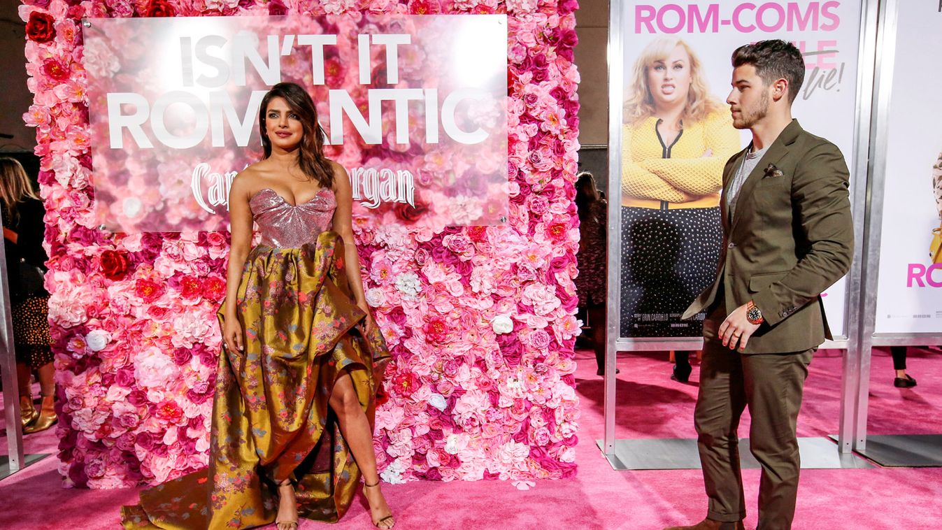 Cast member Chopra poses as husband Jonas watches at the premiere for the movie "Isn't It Romantic" in Los Angeles