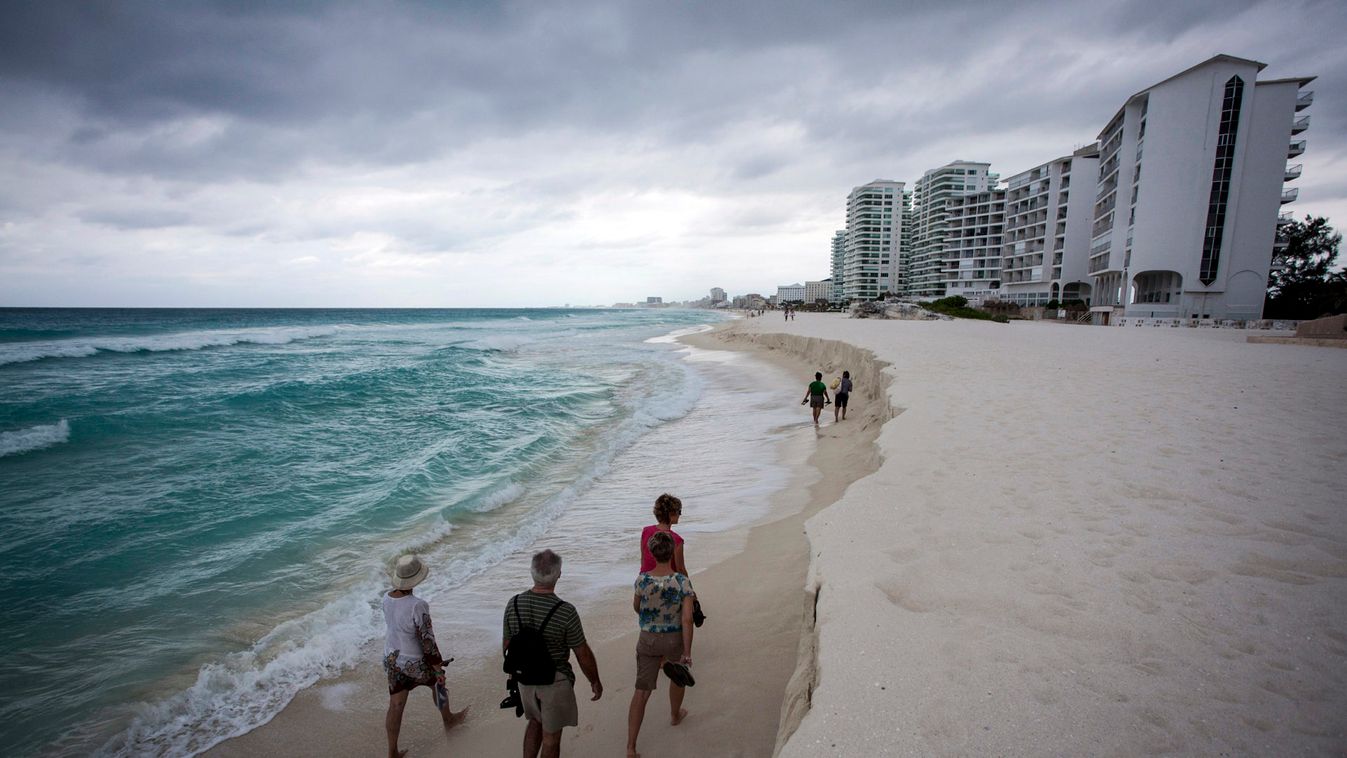 Tourists walk on a beach in Cancun