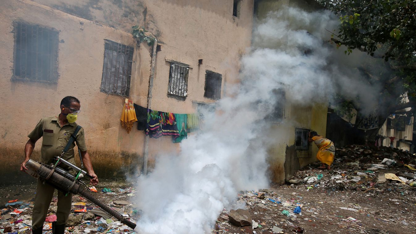 A municipal worker fumigates a slum area to prevent the spread of dengue fever and other mosquito-borne diseases in Mumbai