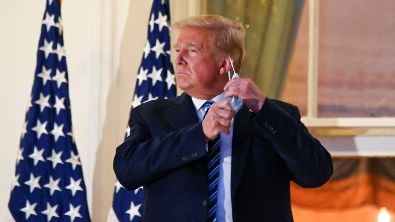 U.S. President Donald Trump pulls off his face mask as he returns to the White House after being hospitalized at Walter Reed Medical Center for coronavirus disease (COVID-19), in Washington