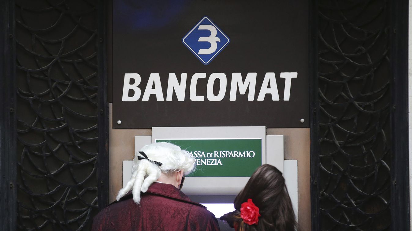 Revellers use an ATM bank machine at San Marco Piazza during the Venice Carnival