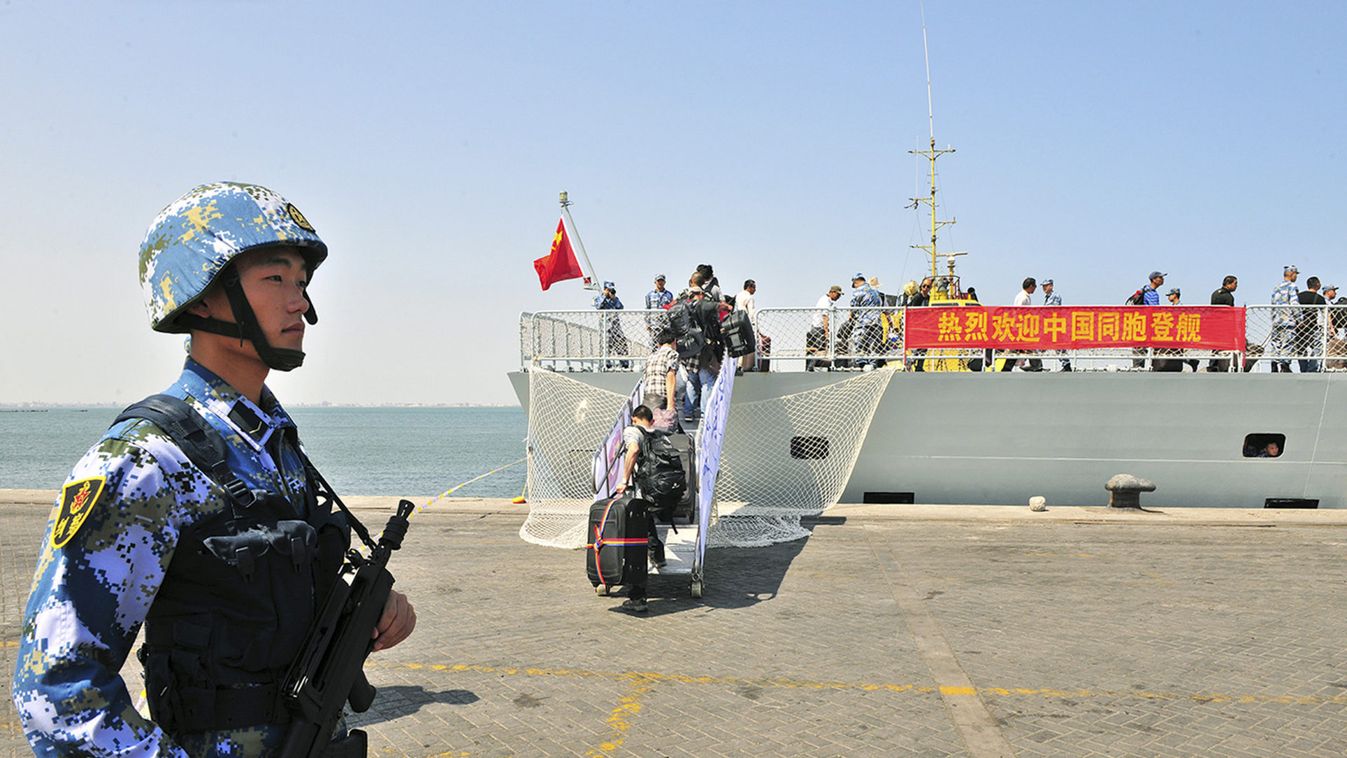 A navy soldier of People's Liberation Army (PLA) stands guard as Chinese citizens board the naval ship "Linyi" at a port in Aden