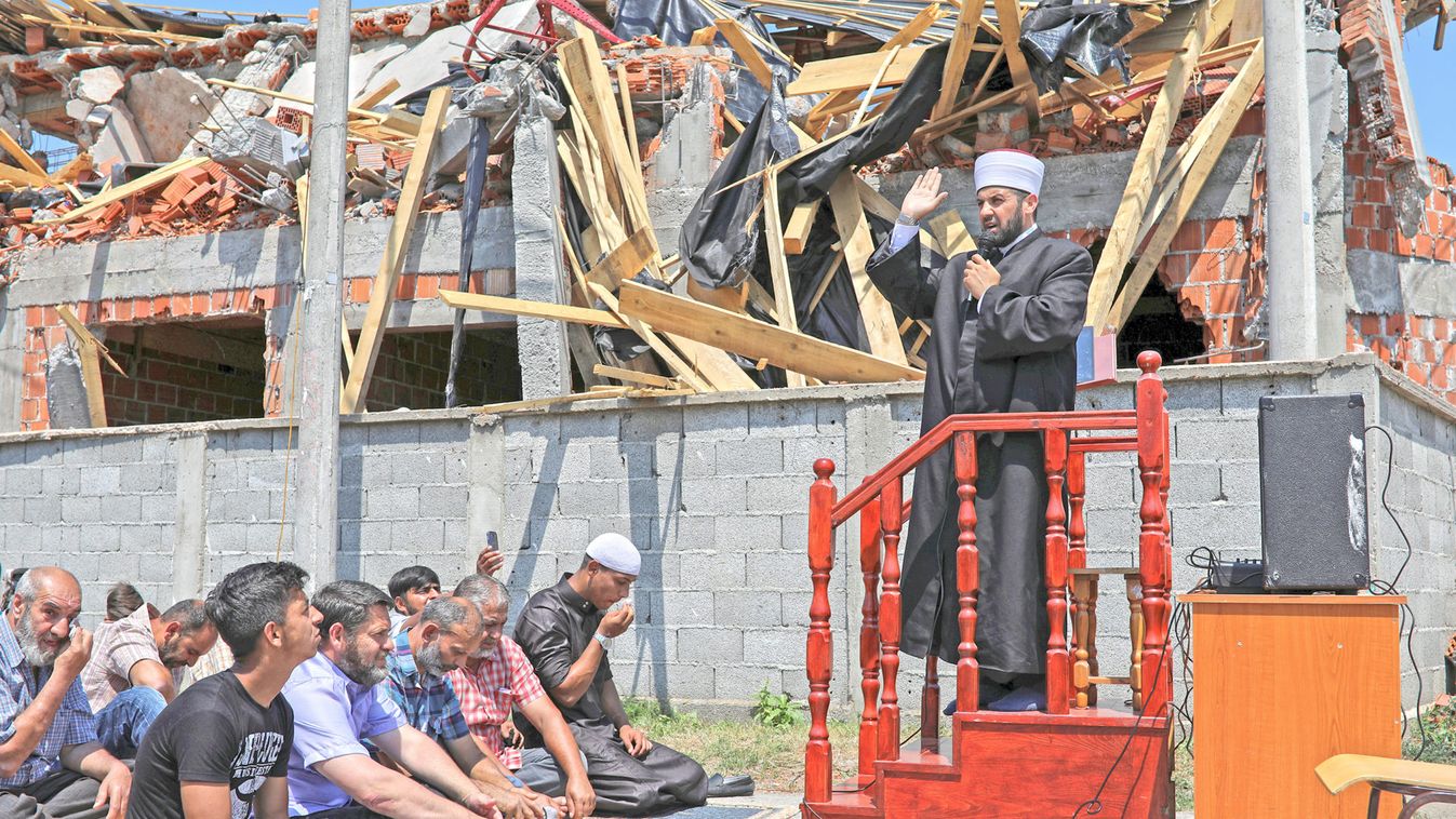 Muslims pray on a street in front of a destroyed illegally built mosque at Zemun Polje district in Belgrade