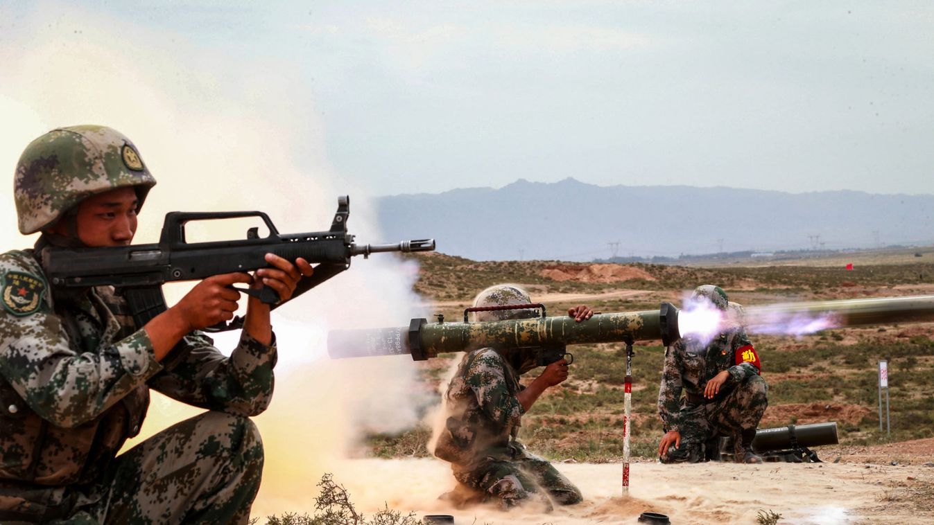 Chinese People's Liberation Army (PLA) soldier(C) fires an anti-tank rocket launcher during a live-fire military exercise in Wuzhong, Ningxia