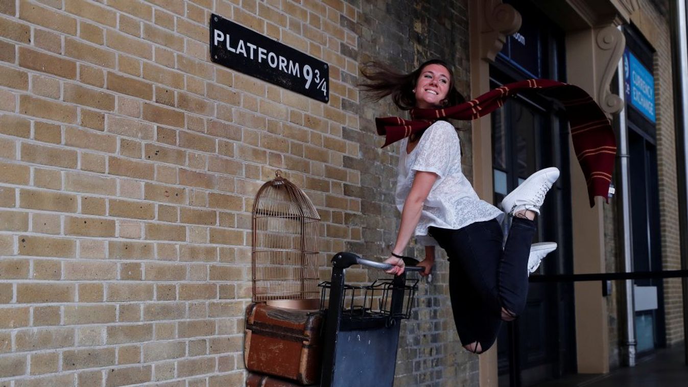 Túrista fotózkodik a King's Cross pályaudvaron Harry Potter mesebeli poggyászával