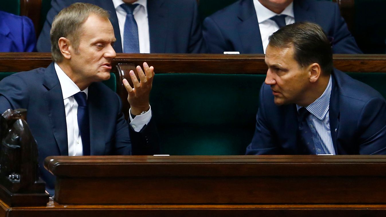 Poland's Prime Minister Donald Tusk gestures as he talks with Foreign Minister Radoslaw Sikorski at the parliament in Warsaw