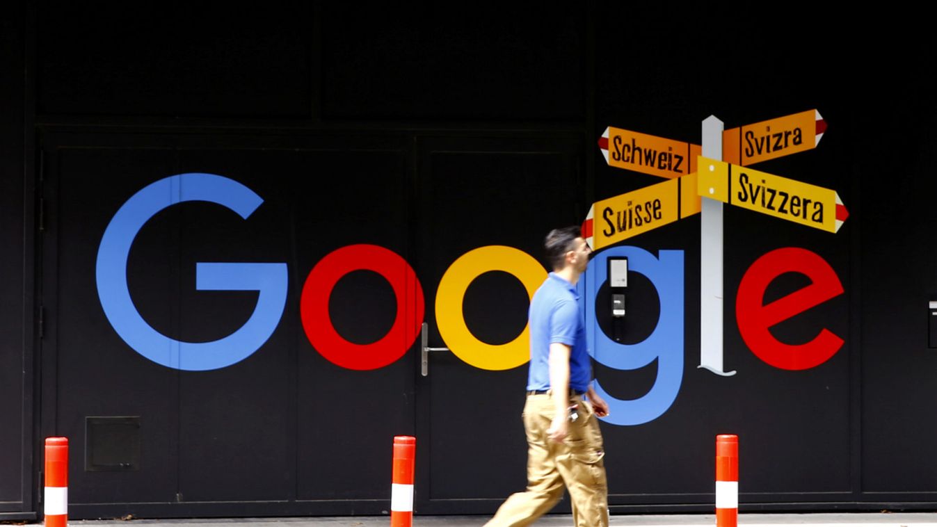 A man walks past a logo of Google in Zurich