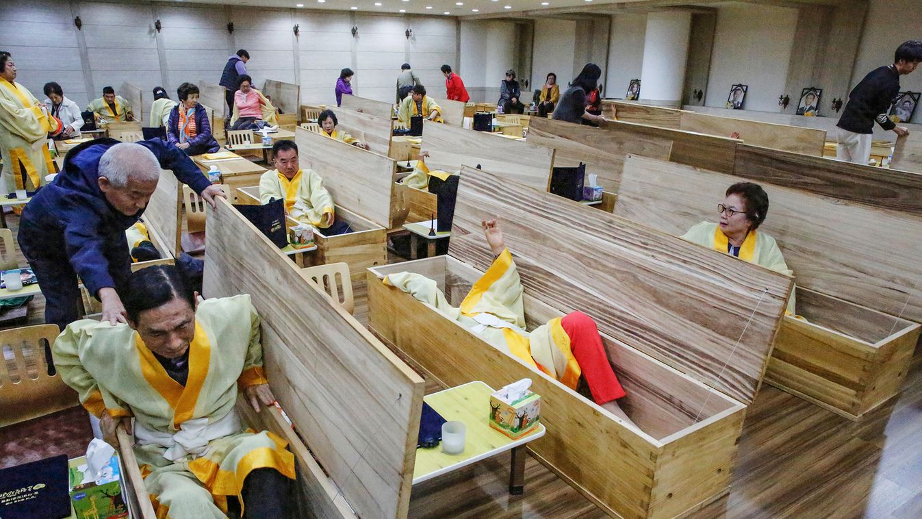 Participants get into coffins during a "living funeral" event as part of a "dying well" programme, in Seoul, South Korea