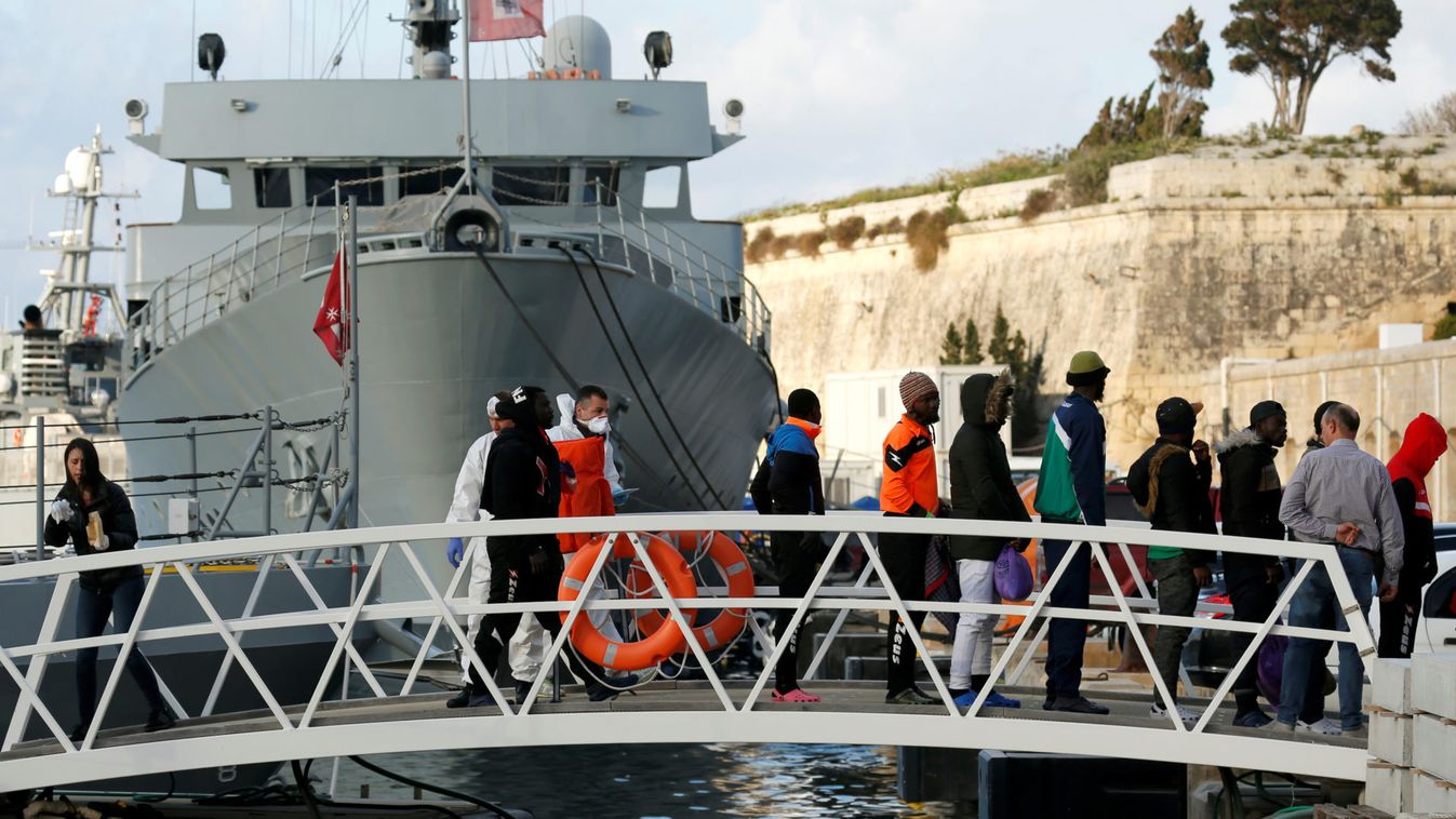 Migrants who were stranded on the German NGO Sea-Eye migrant rescue ship Alan Kurdi disembark from an Armed Forces of Malta patrol boat at its base in Marsamxett Harbour, Valletta