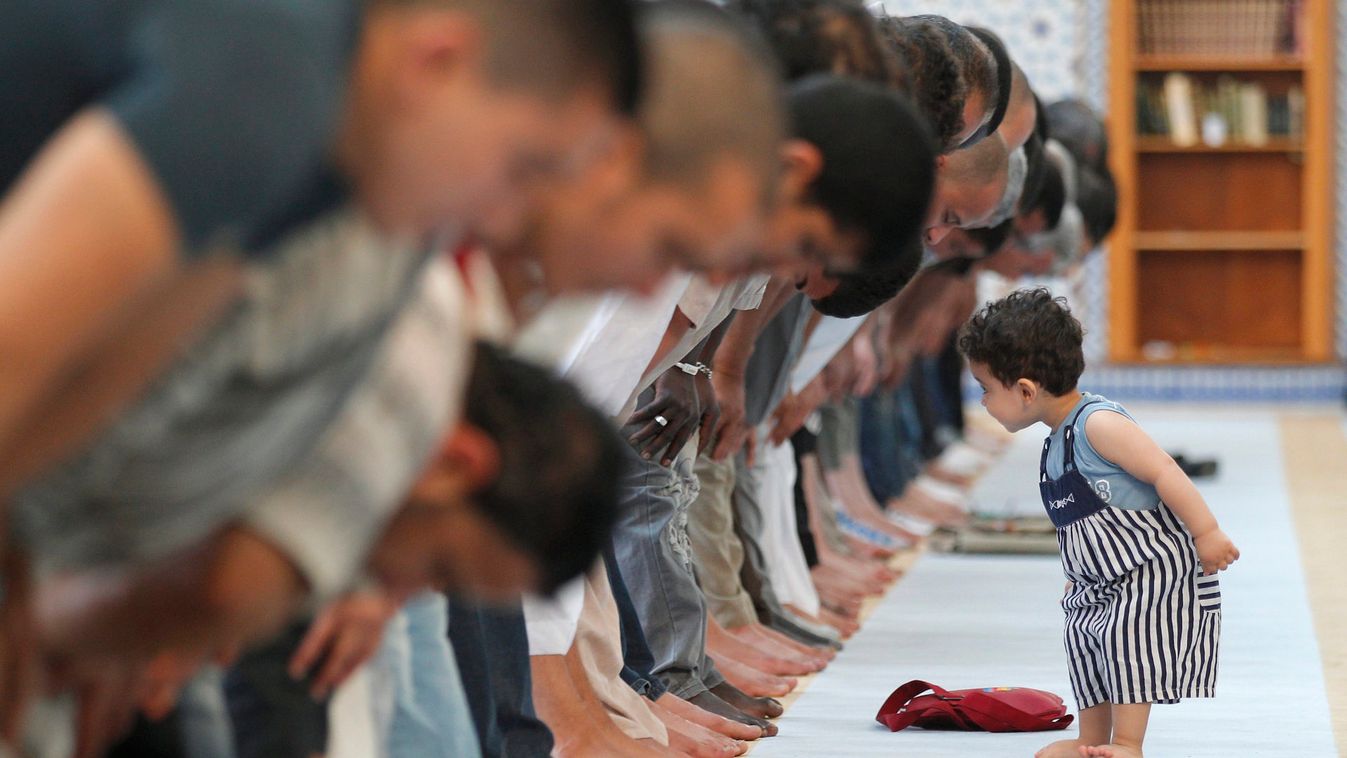 A child walks near members of the Muslim community attending midday prayers at Strasbourg Grand Mosque in Strasbourg