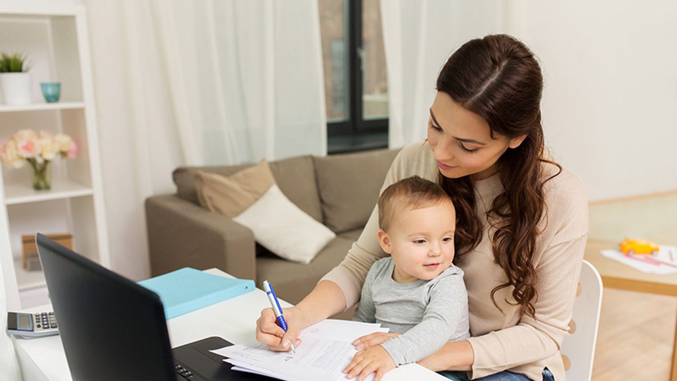 happy mother with baby and papers working at home
