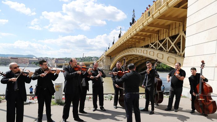 A music band plays music next to the Margaret bridge in respect for the victims from a boat carrying South Korean tourists capsized on the Danube river, in Budapest