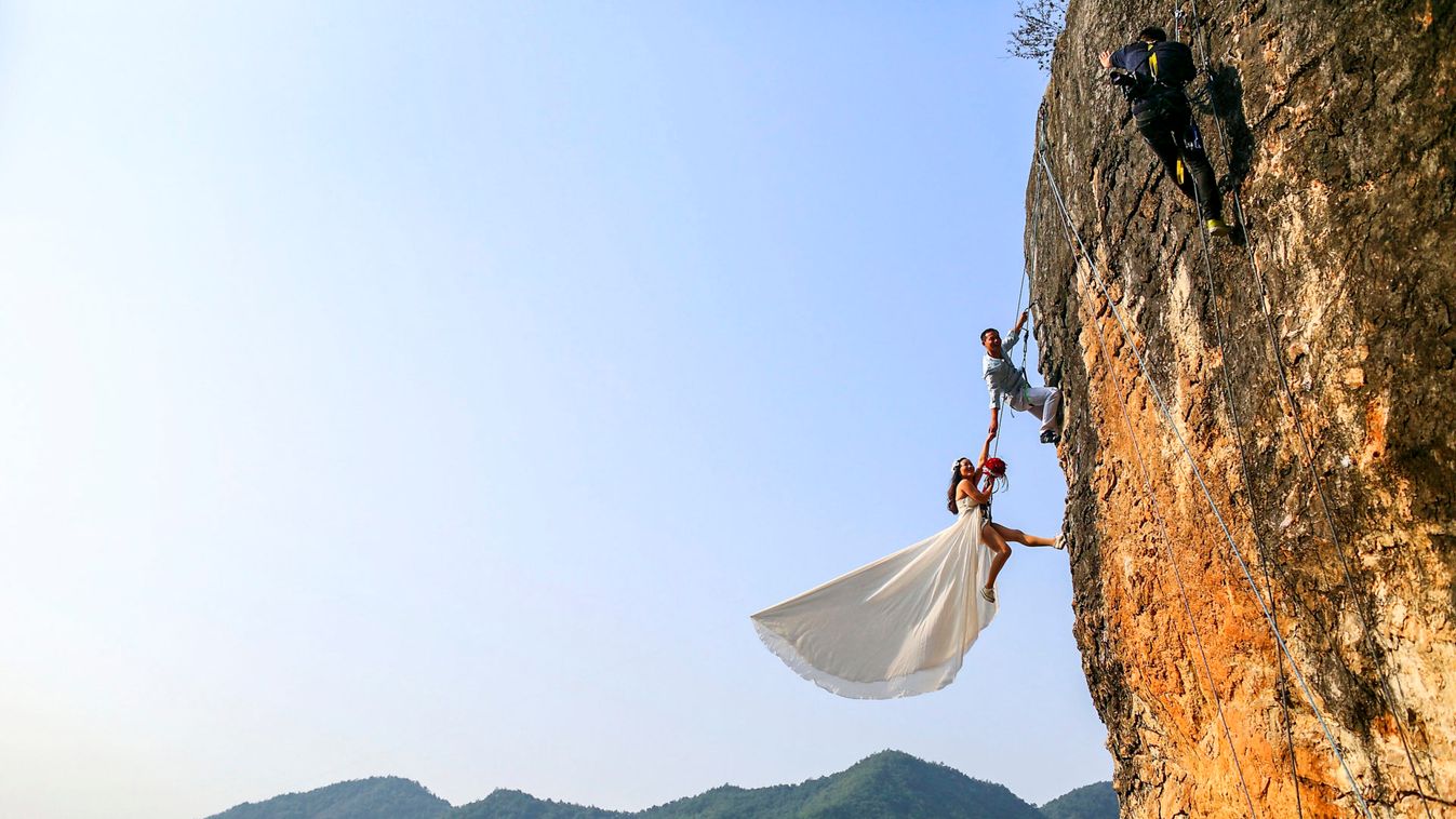 Zheng Feng, an amateur climber takes wedding pictures with his bride on a cliff in Jinhua