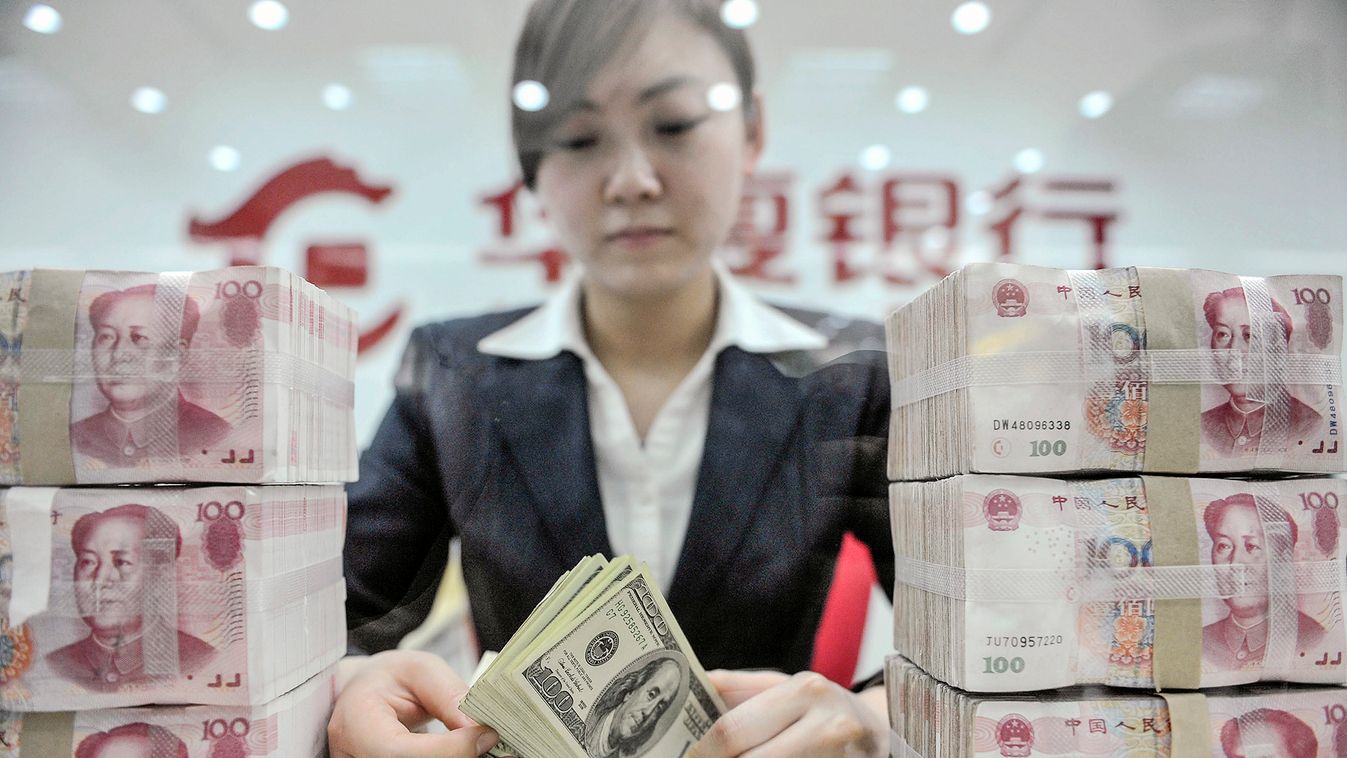 An employee counts U.S. dollar banknotes at a branch of Huaxia Bank in Shenyang, Liaoning province
