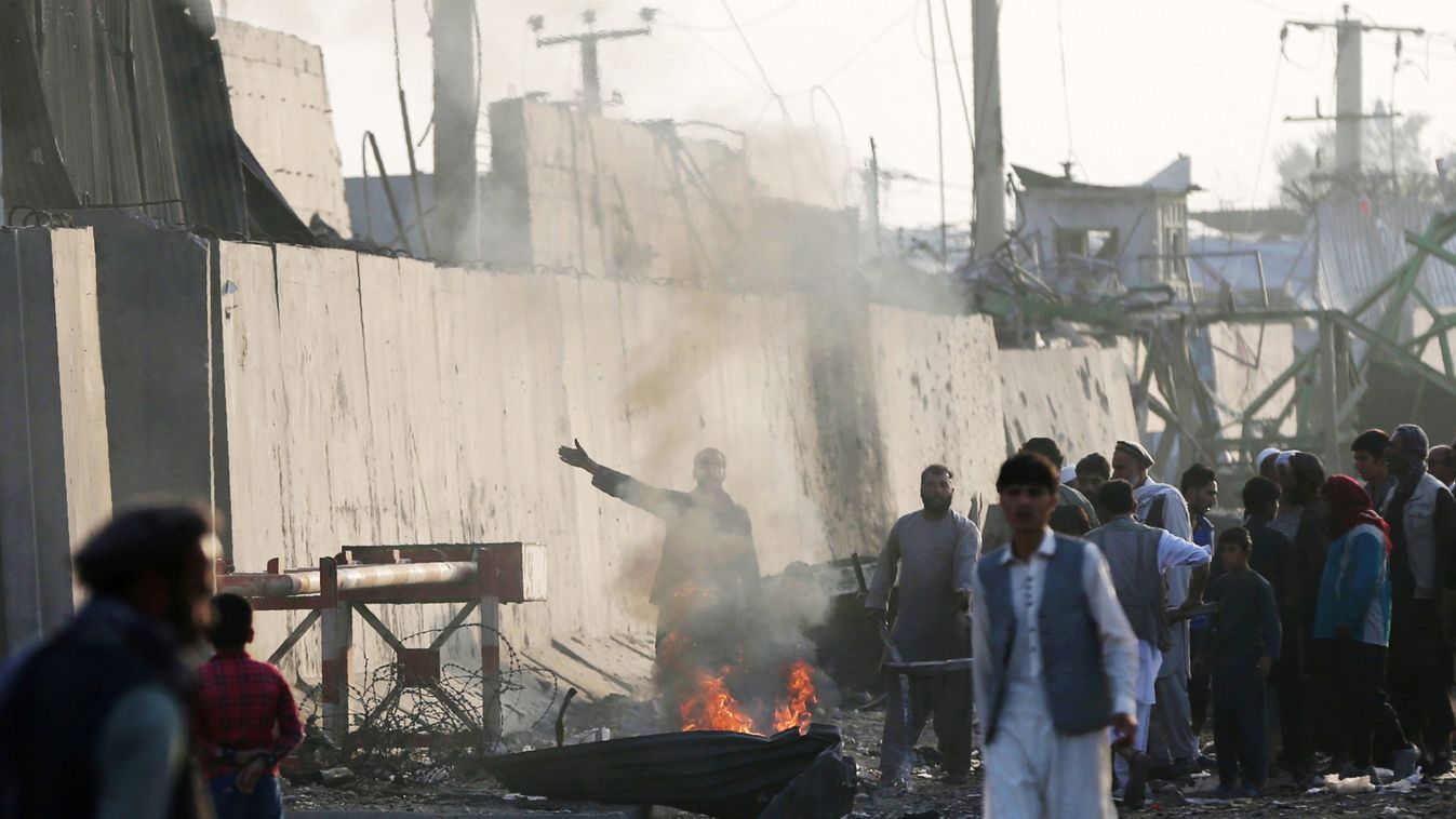 Angry Afghan protesters burn tires and shout slogans at the site of a blast in Kabul, Afghanistan
