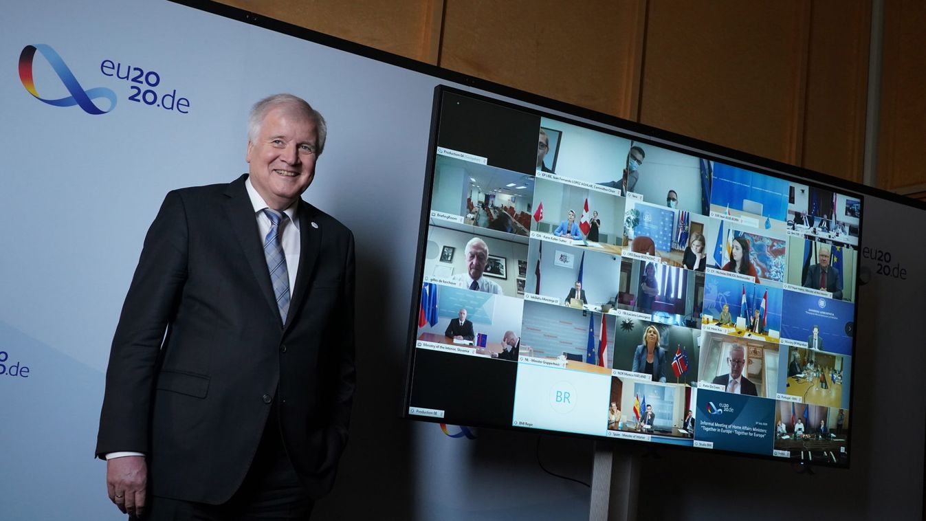 Horst Seehofer német belügyminiszter a többi résztvevõt mutató képernyõ mellett áll az EU-tagországok belügyminisztereinek videokonferenciája elõtt Berlinben