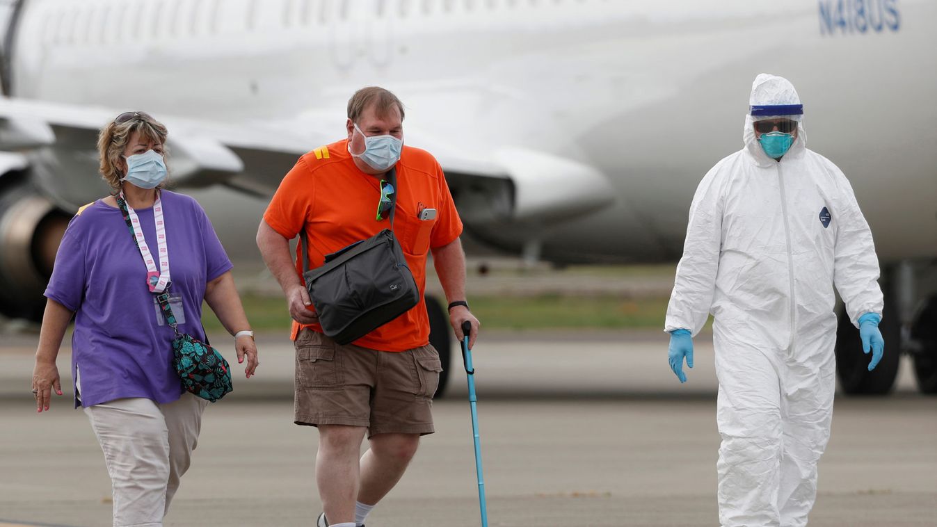 Passengers from the cruise ship Grand Princess walks on the tarmac at Oakland International Airport as authorities continue debarkation from the ship after 21 people on board have tested positive for the COVID-19 coronavirus disease in Oakland