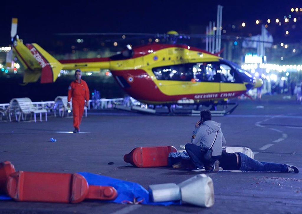 An injured individual is seen on the ground after at least 30 people were killed in the southern French town of Nice when a truck ran into a crowd celebrating the Bastille Day national holiday