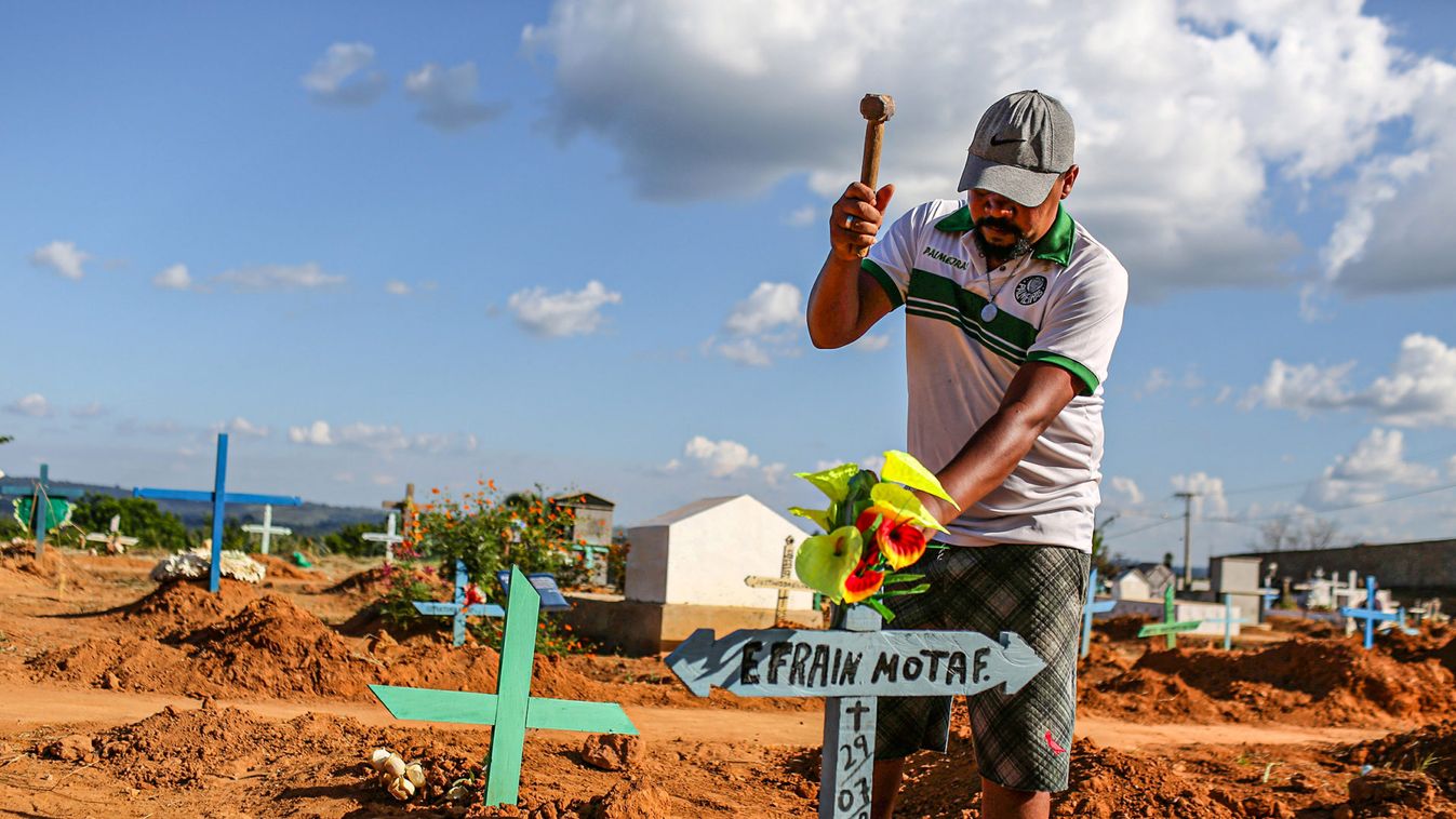 A relative places a cross to identify the grave of Efraim Mota, 22, a prisoner who died in a prison riot, at the Sao Sebastiao cemetery in the city of Altamira