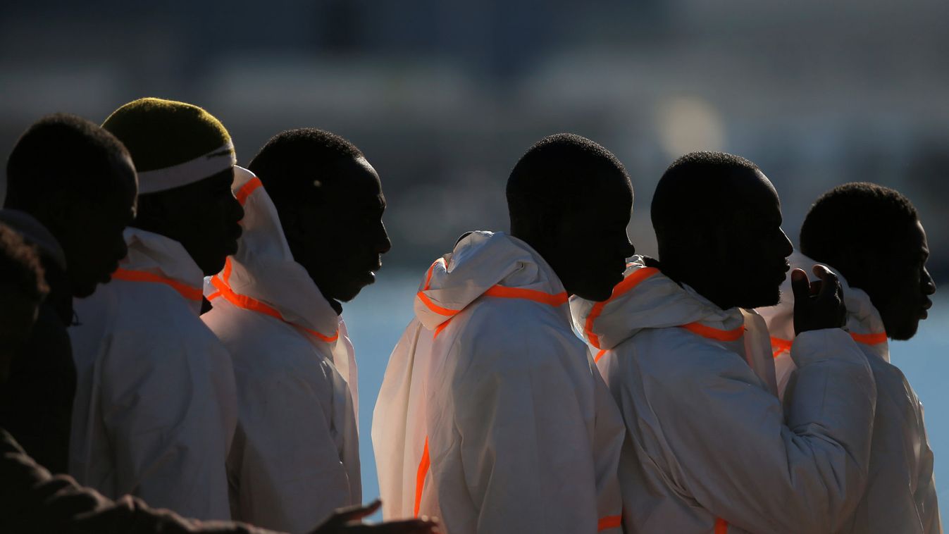 Migrants wait in line after arriving on a rescue boat at the port of Malaga