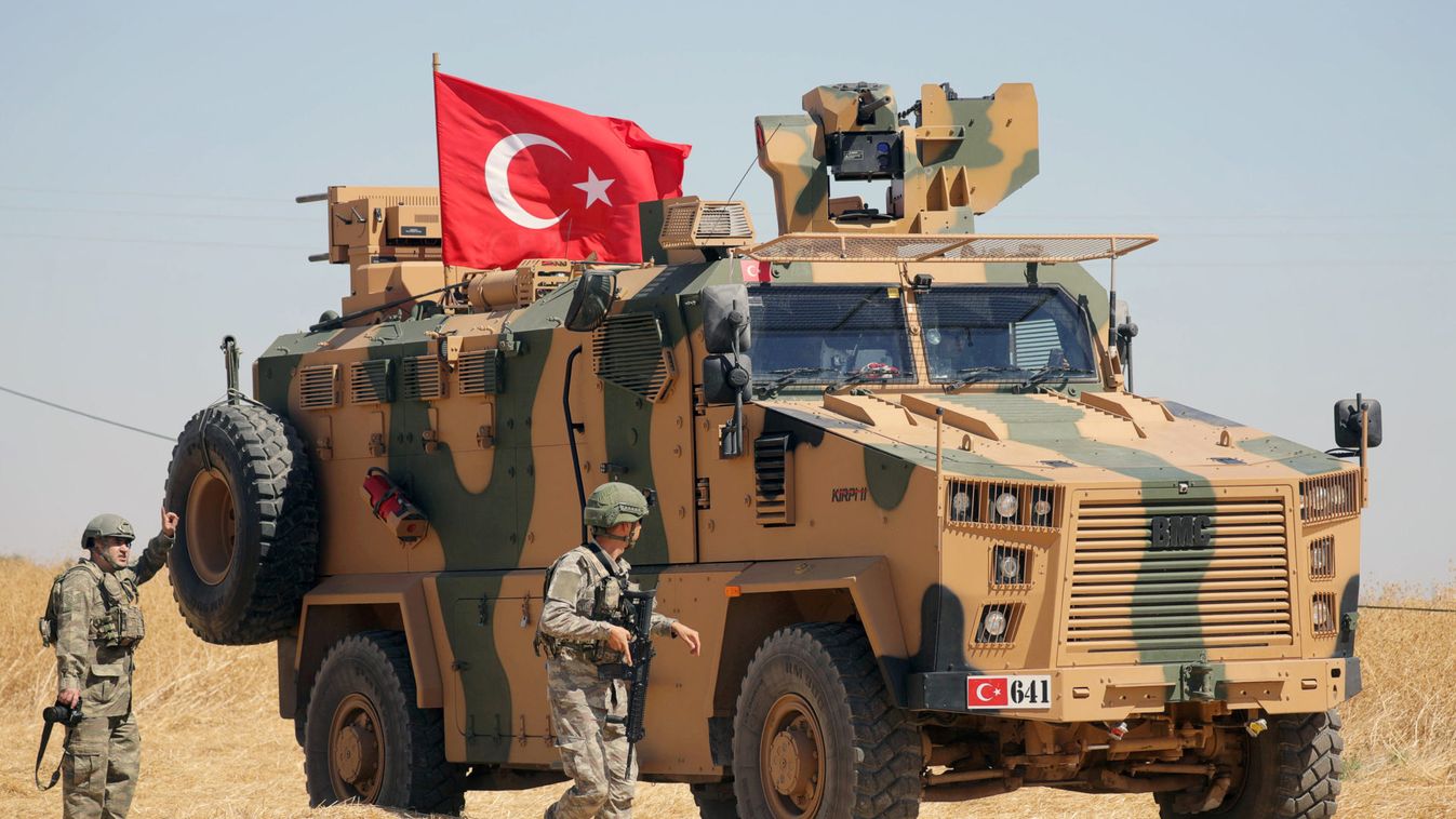 A Turkish soldier walks next to a Turkish military vehicle during a joint U.S.-Turkey patrol, near Tel Abyad