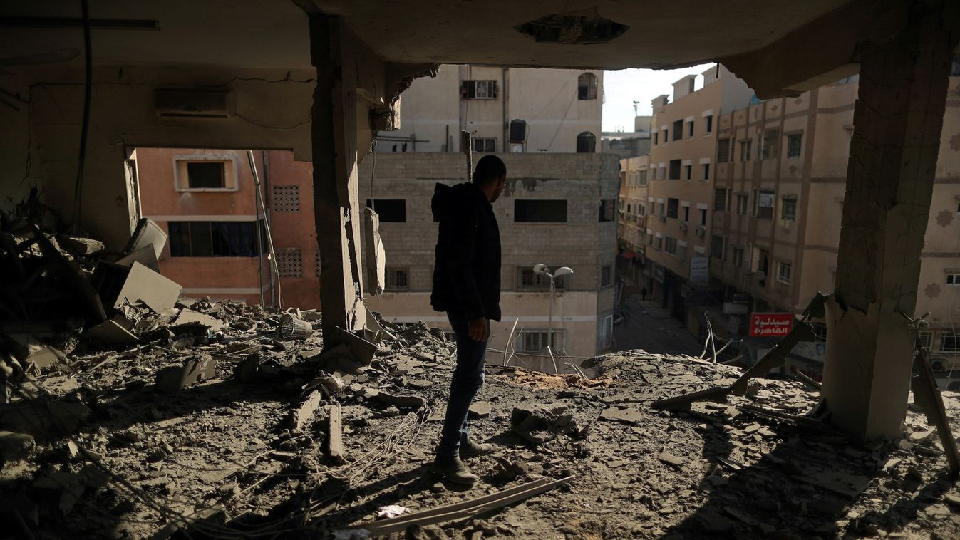 Palestinian man inspects a building destroyed in Israeli air strikes, in Gaza City