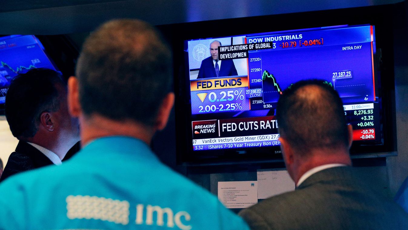 Traders look on as a screen shows the U.S. Federal Reserve interest rates announcement on the floor of the New York Stock Exchange (NYSE) in New York