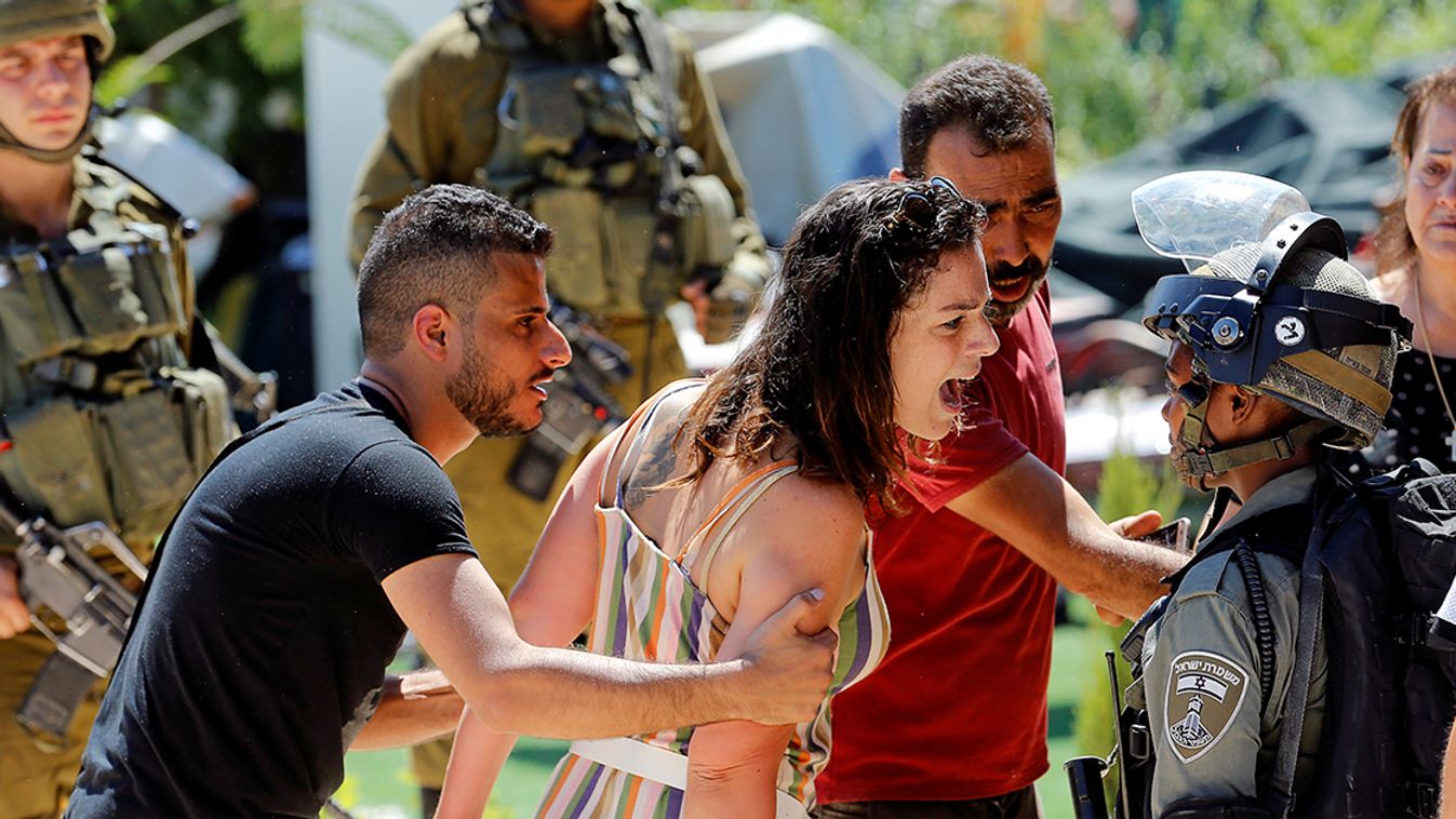 Palestinian woman argues with an Israeli border policewoman over the Israeli demolition of a building housing an apartment and a restaurant in Beit Jala in the Israeli-occupied West Bank