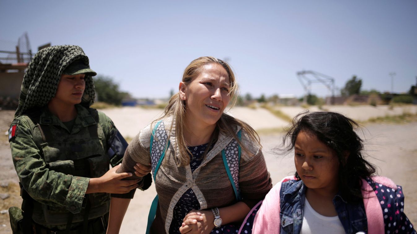 A member of Mexico's National Guard escorts a woman and her daughter from Nicaragua after detaining them while they were trying to cross illegally the border between the U.S. and Mexico, in Ciudad Juarez