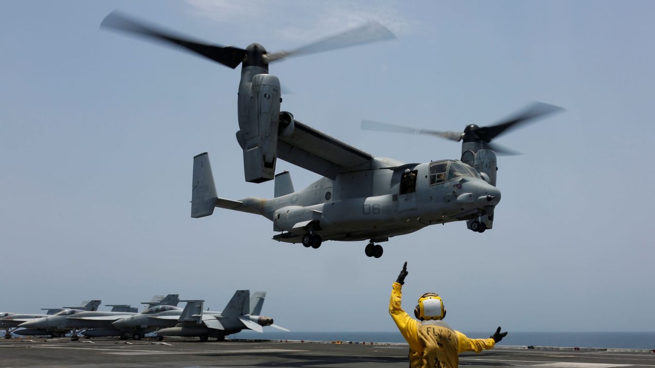 A flight deck crew signals an MV-22 to land on the flight deck of the aircraft carrier USS Abraham Lincoln in the Arabian Sea
