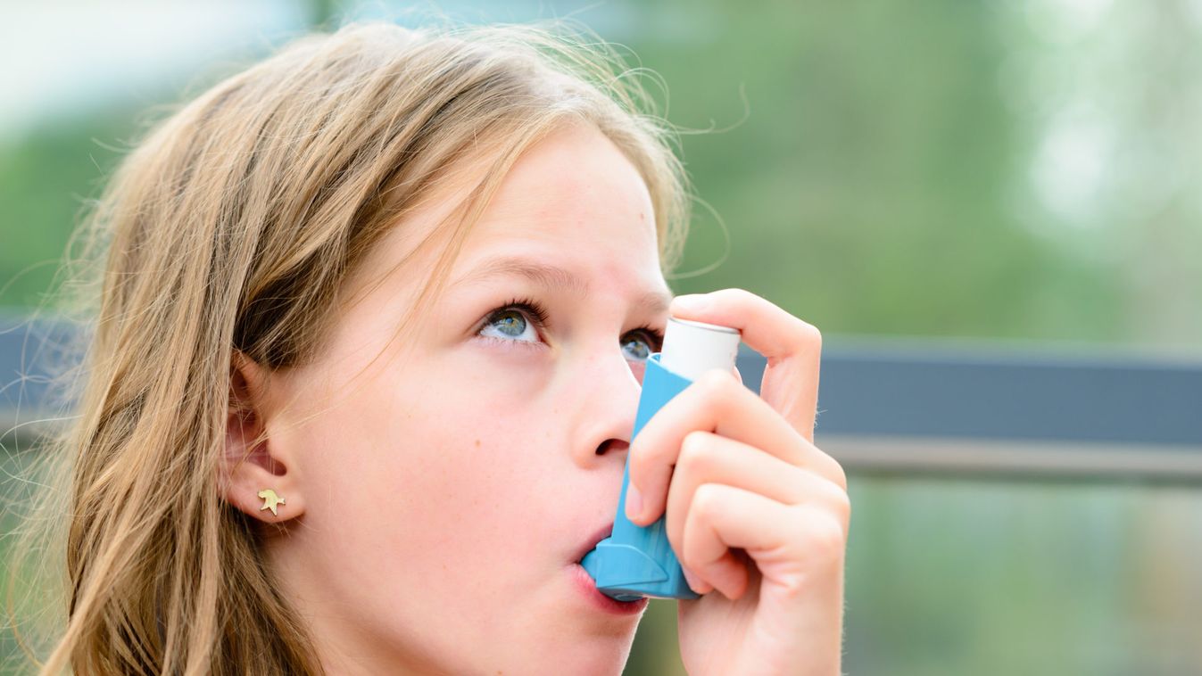 Girl having asthma using the asthma inhaler 
