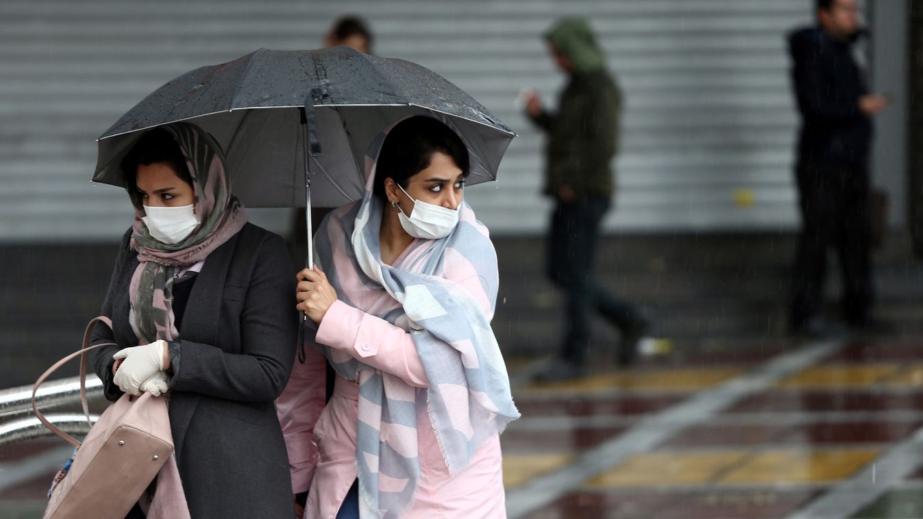 Iranian women wear protective masks to prevent contracting coronavirus, as they walk in the street in Tehran