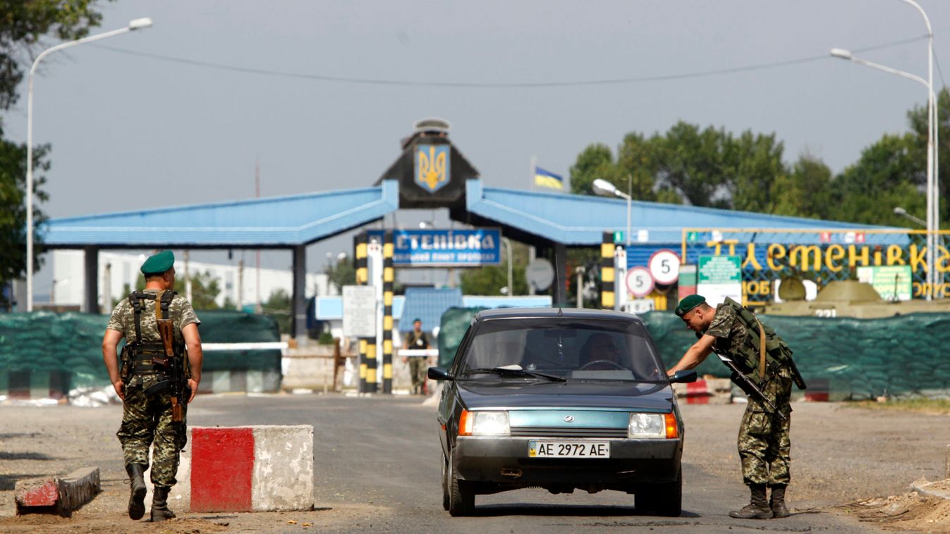 A Ukrainian border guard checks a car at the crossing point Pletenivka near the border with Russia, in the Kharkiv region