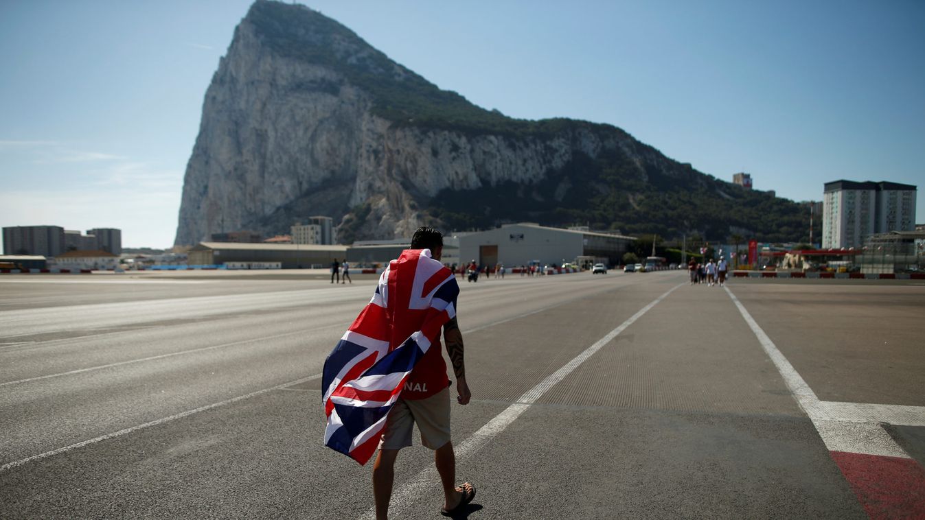 A British resident living in Gibraltar walks with the Union Jack flag draped around his shoulders during the Gibraltar National Day celebrations, in the British overseas territory of Gibraltar