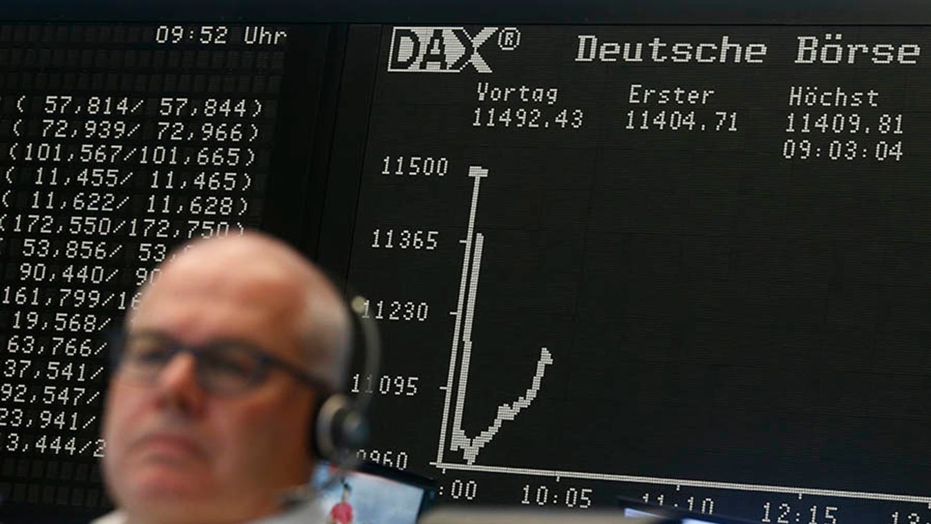 A trader sits in front of the DAX board at his desk at the Frankfurt stock exchange
