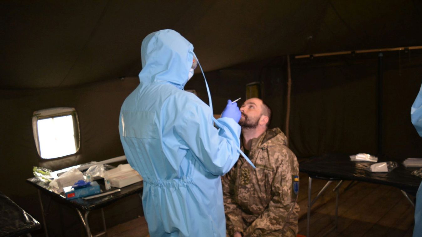 A medical specialist tests a Ukrainian serviceman for coronavirus disease near the front line in Donetsk region