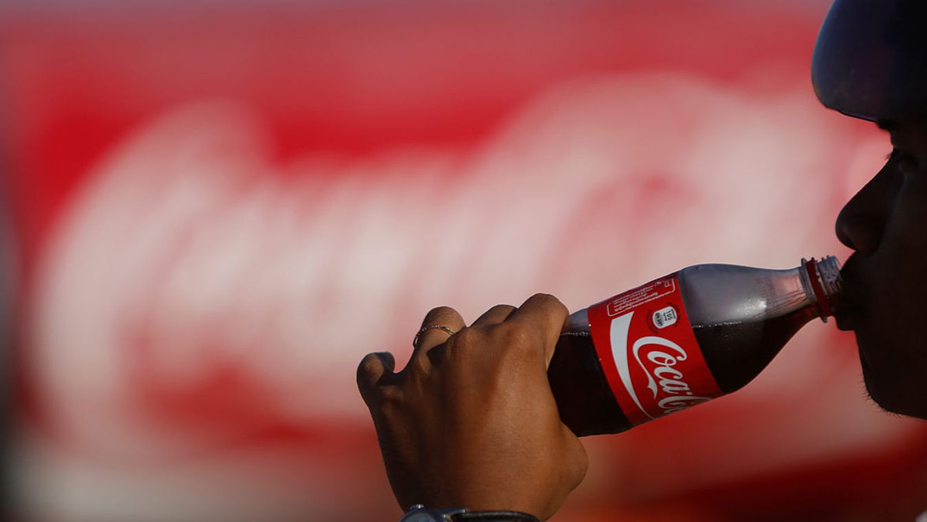 A man drinks a Coca-Cola at a store in Phnom Penh