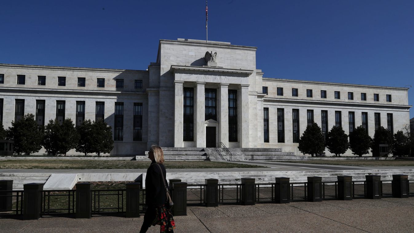 A pedestrian walks past the Federal Reserve Board building on Constitution Avenue in Washington