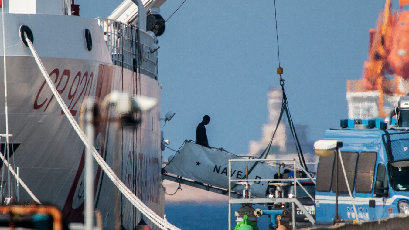 A rescued migrant disembarks from Italian coastguard ship Gregoretti in Augusta
