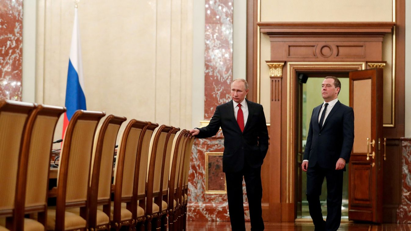Russian President Putin and Prime Minister Medvedev speak before a meeting with government members in Moscow