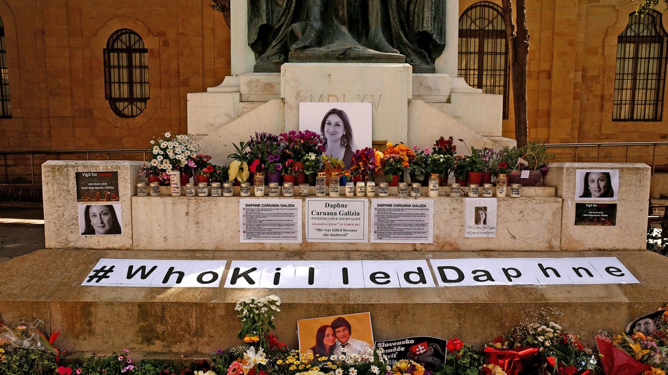 Photos of assassinated Maltese journalist Daphne Caruana Galizia and Slovak journalist Jan Kuciak and his fiancee Martina Kusnirova are seen on a makeshift memorial to Caruana Galizia, who was killed by a car bomb in 2017, in Valletta