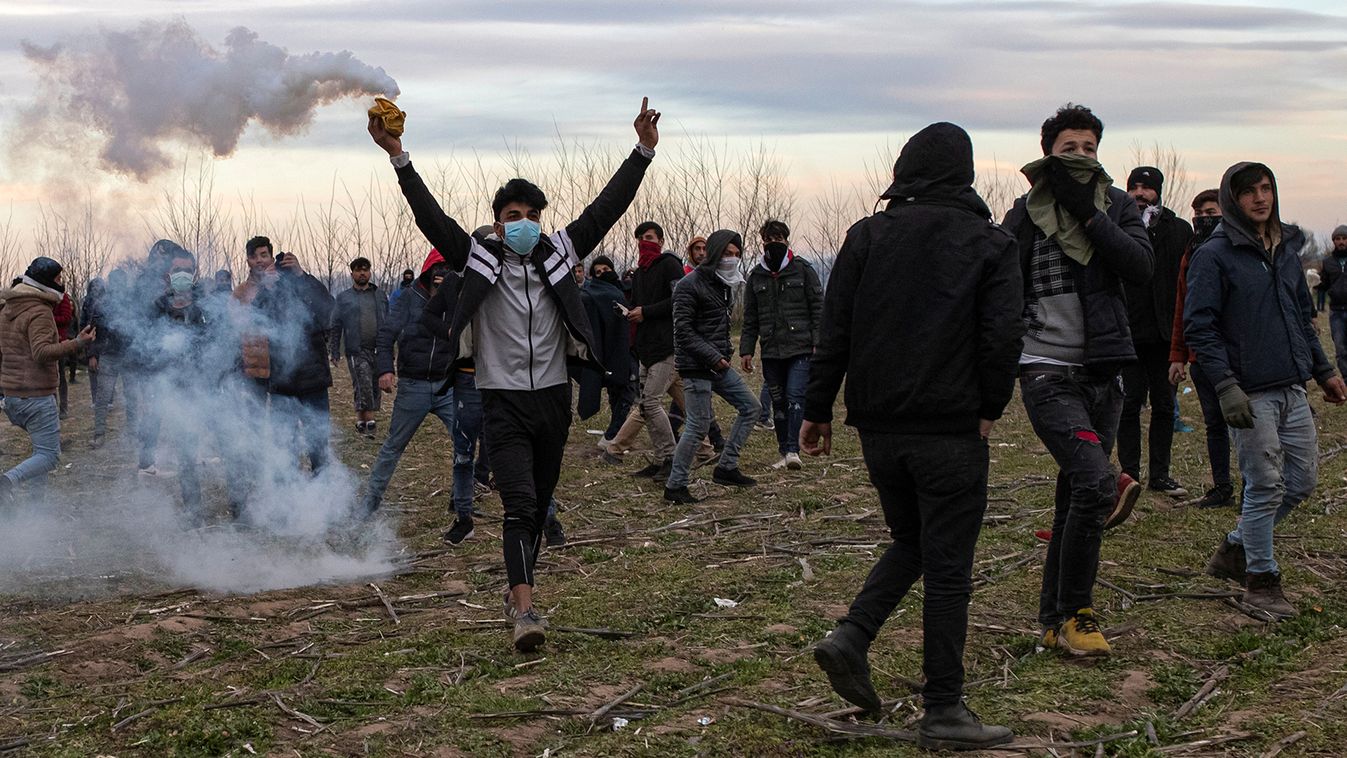 A migrant holds a tear gas canister as they clash with Greek riot police at Turkey's Pazarkule border crossing with Greece's Kastanies, near Edirne