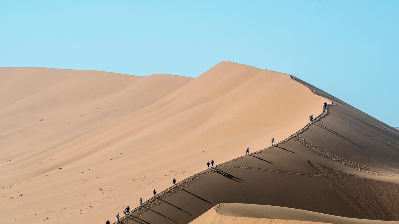 Tourists climbing a sand dune next to Deadvlei in Sossusvlei