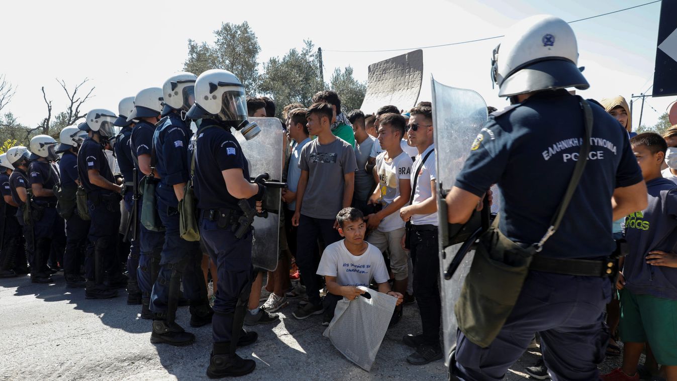 Refugees and migrants are blocked by riot police during a demonstration against living conditions at the Moria camp on the island of Lesbos