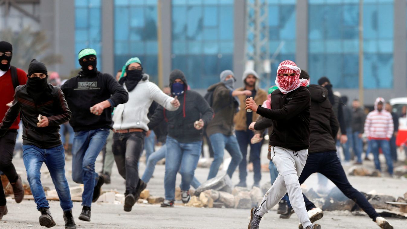 Palestinian stone-throwers run during clashes with Israeli forces near the Jewish settlement of Beit El, in the Israeli-occupied West Ban