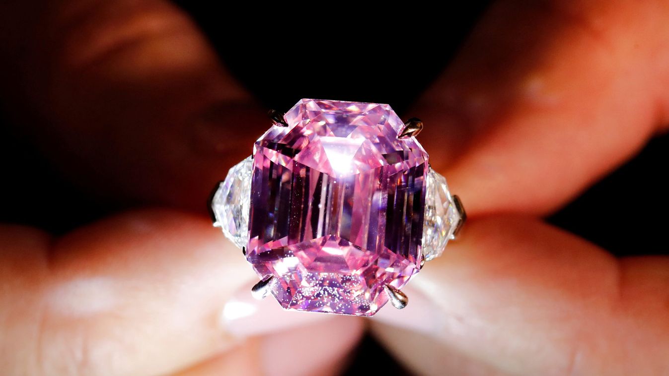 A Christie's staff holds a 18.96 carat Fancy Vivid Pink Diamond during a preview in Geneva