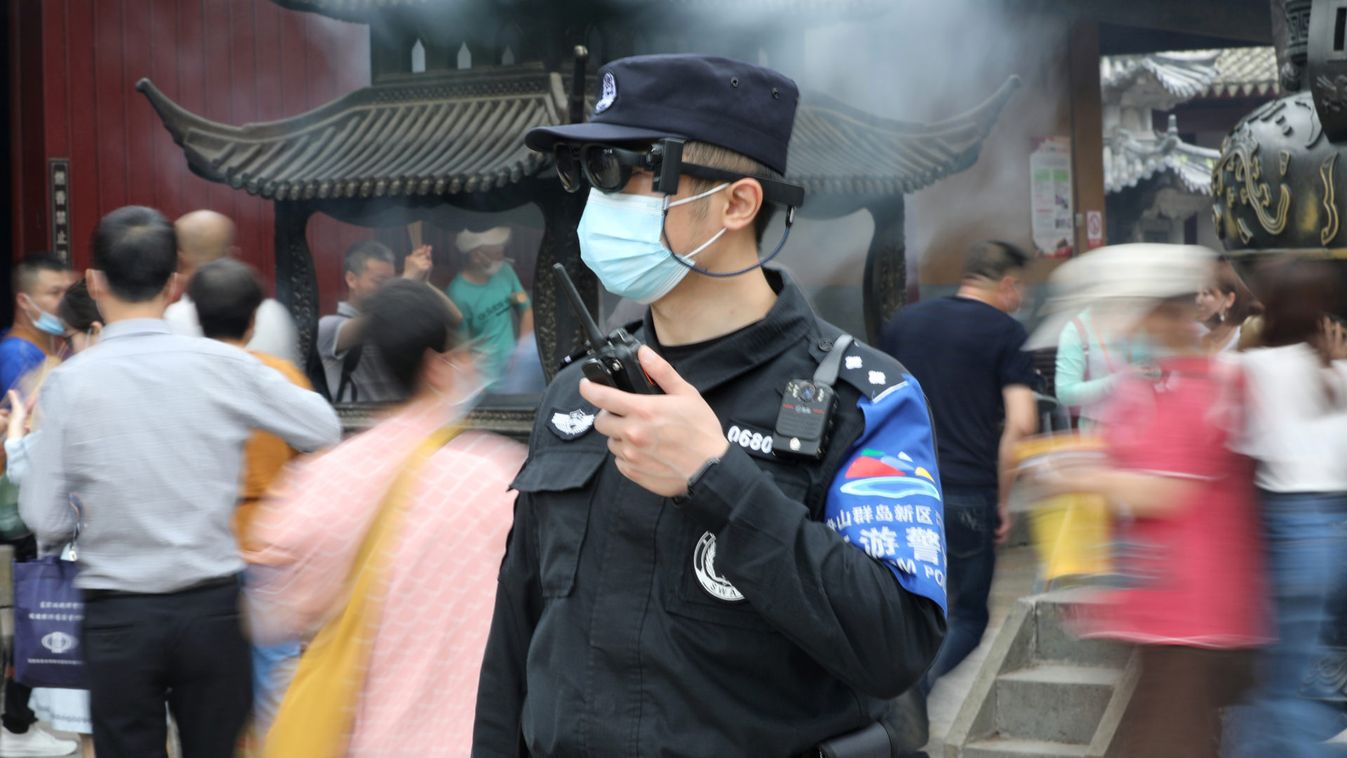 Police officer wearing AR glasses that can measure temperatures keeps watch at a tourist attraction at Putuo Mountain in Zhoushan