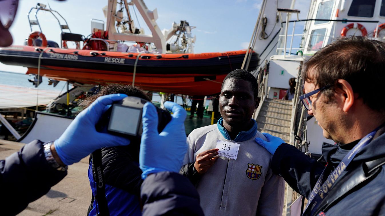 Police take a migrant's photo after he was rescued by NGO Proactiva Open Arms rescue boat in central Mediterranean Sea, at the Port of Taranto