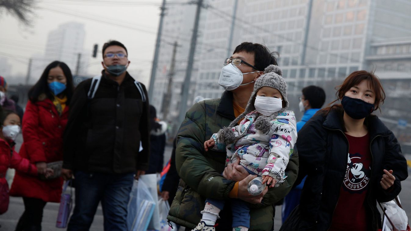 People wear face masks as they cross a street on a polluted day in Beijing